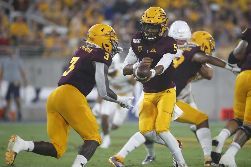 Arizona State quarterback Jayden Daniels (5) hands the ball off to running back Eno Benjamin (3) during the first half of the team's NCAA college football game against Kent State, Thursday, Aug. 29, 2019, in Tempe, Ariz. (AP Photo/Ralph Freso)