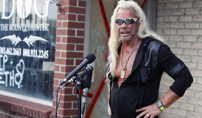 This Aug. 2, 2019 file photo shows Duane &quot;Dog the Bounty Hunter&quot; Chapman talking to reporters outside his storefront that was burglarized in Edgewater, Colo. (AP Photo/David Zalubowski, File)