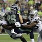 Seattle Seahawks tight end Jacob Hollister (48) scores a touchdown after a reception as he is tackled by Oakland Raiders&#39; Te&#39;Von Coney, left, and Jordan Richards, right, during the first half of an NFL football preseason game Thursday, Aug. 29, 2019, in Seattle. (AP Photo/Elaine Thompson)