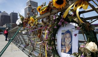 In this July 17, 2015, file photo, flowers and a portrait of Kate Steinle remain at a memorial site on Pier 14 in San Francisco. (Paul Chinn/San Francisco Chronicle via AP, File)
