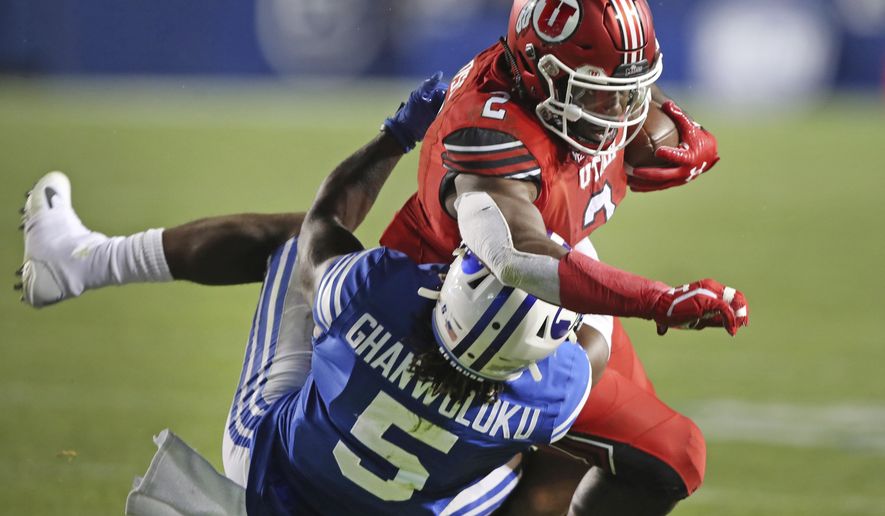 BYU defensive back Dayan Ghanwoloku (5) takes down Utah running back Zack Moss (2) in the second half during an NCAA college football game, Thursday, Aug. 29, 2019, in Provo, Utah. (AP Photo/George Frey)