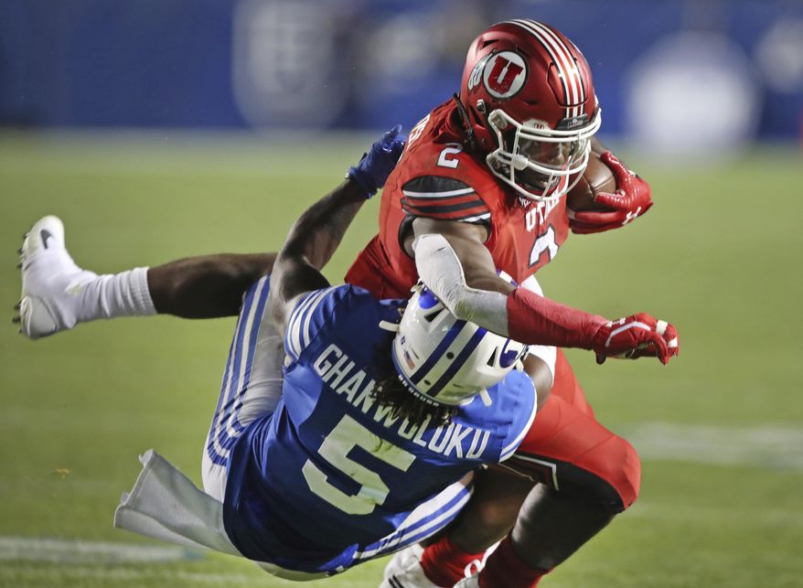 BYU defensive back Dayan Ghanwoloku (5) takes down Utah running back Zack Moss (2) in the second half during an NCAA college football game, Thursday, Aug. 29, 2019, in Provo, Utah. (AP Photo/George Frey)