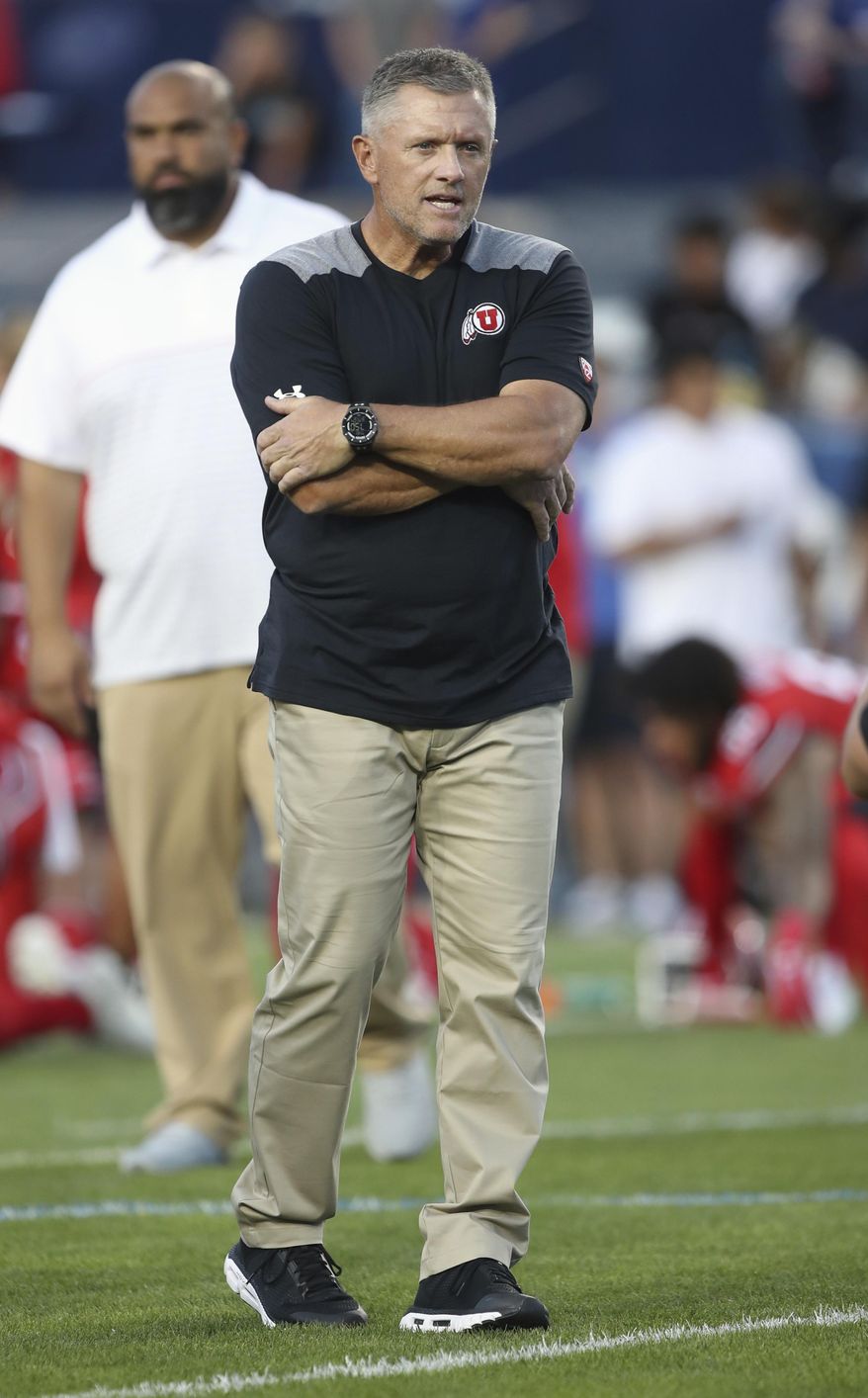 Utah coach Kyle Whittingham watches his team warm up for an NCAA college football game against BYU, Thursday, Aug. 29, 2019, in Provo, Utah. (AP Photo/George Frey)