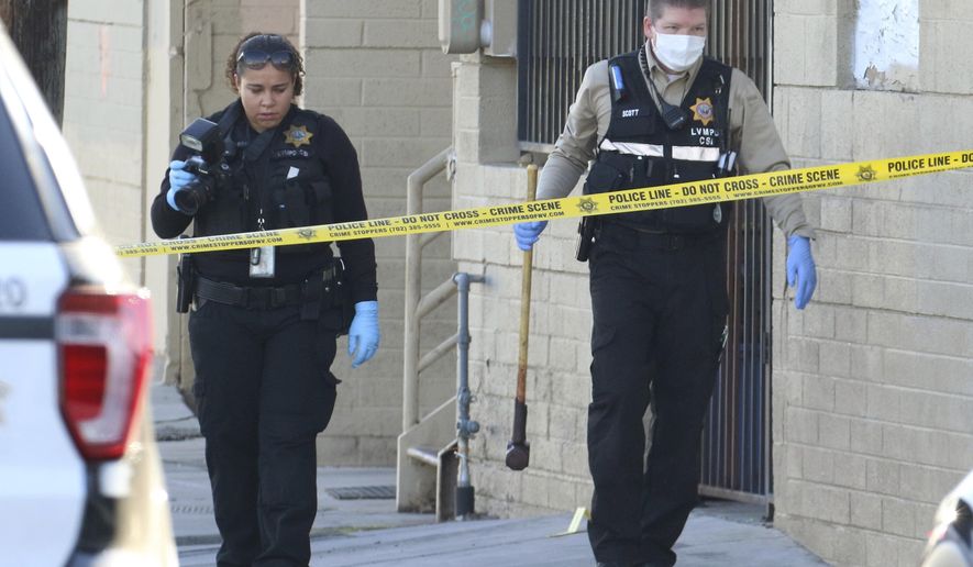 Las Vegas police collect evidence at the crime scene where a woman was killed by a sledgehammer on Thursday, Aug. 29, 2019, in Las Vegas. Police don't believe a woman knew a man accused of bludgeoning her to death with a sledgehammer while her 911 call from a Las Vegas laundromat went dead, authorities said Thursday. (Bizuayehu Tesfaye/Las Vegas Review-Journal via AP)