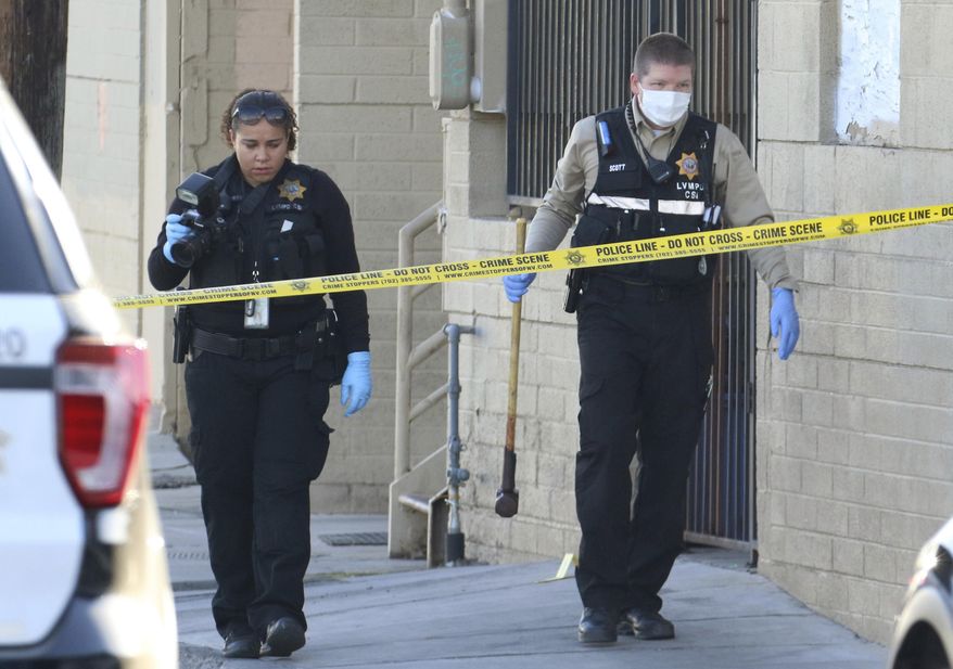 Las Vegas police collect evidence at the crime scene where a woman was killed by a sledgehammer on Thursday, Aug. 29, 2019, in Las Vegas. Police don't believe a woman knew a man accused of bludgeoning her to death with a sledgehammer while her 911 call from a Las Vegas laundromat went dead, authorities said Thursday. (Bizuayehu Tesfaye/Las Vegas Review-Journal via AP)