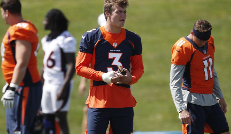 His right hand wrapped because of a thumb injury, Denver Broncos rookie quarterback Drew Lock looks on as teammates take part in an NFL football practice Tuesday, Aug. 27, 2019, at the team's headquarters in Englewood, Colo. (AP Photo/David Zalubowski)