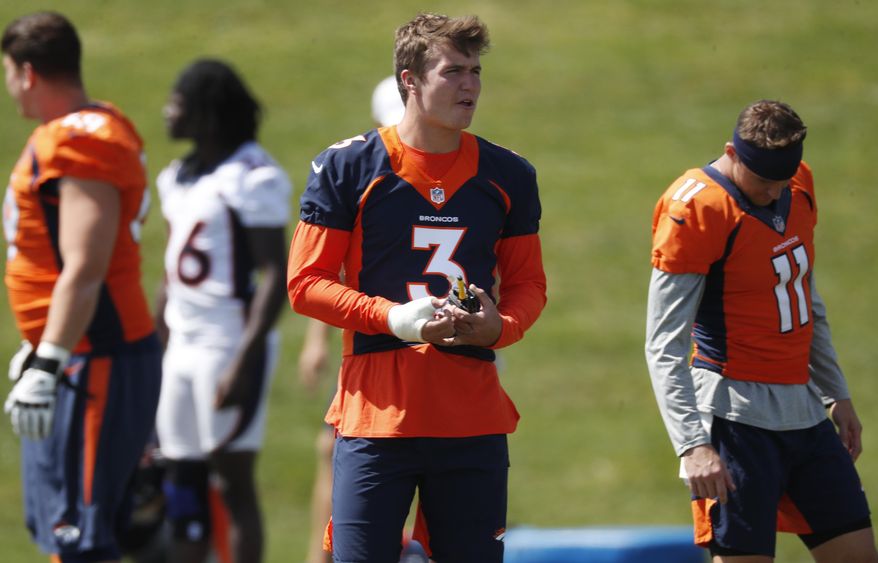 His right hand wrapped because of a thumb injury, Denver Broncos rookie quarterback Drew Lock looks on as teammates take part in an NFL football practice Tuesday, Aug. 27, 2019, at the team's headquarters in Englewood, Colo. (AP Photo/David Zalubowski)