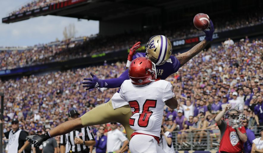 Washington's Aaron Fuller makes a one-handed catch for a touchdown over Eastern Washington's Darreon Moore (26) in the first half of an NCAA college football game Saturday, Aug. 31, 2019, in Seattle. (AP Photo/Elaine Thompson)