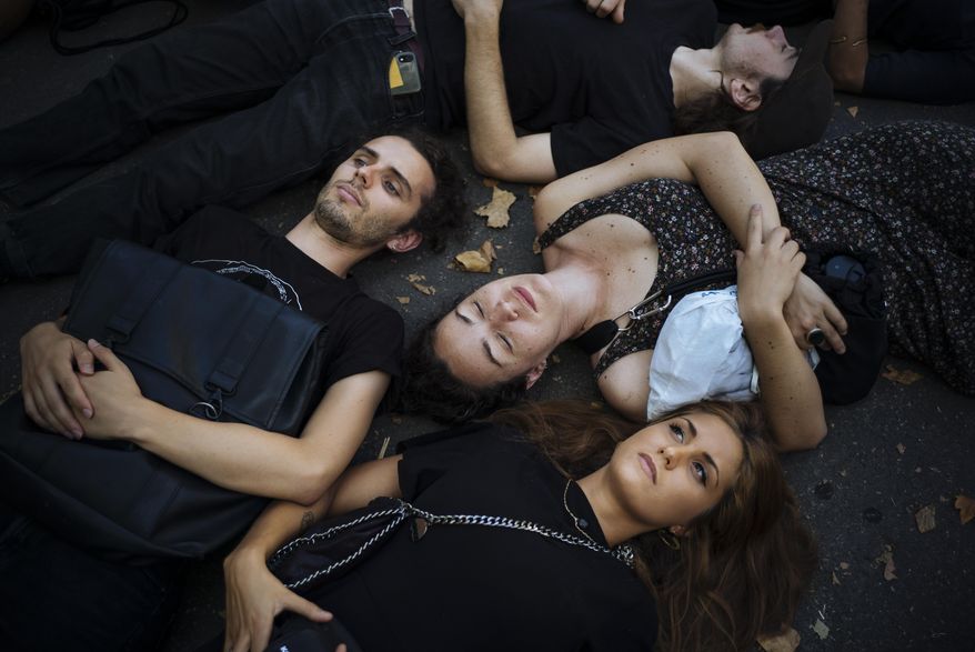 Extinction Rebellion activists lay on the ground as they protest in Paris, Saturday, Aug. 31, 2019, to call on Brazil's President Jair Bolsonaro to act to protect the Amazon rainforest. (AP Photo/Kamil Zihnioglu)