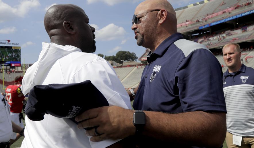 Maryland head coach Michael Locksley, left, shakes hands with Howard head coach Ron Prince after an NCAA college football game, Saturday, Aug. 31, 2019, in College Park, Md. Maryland won 79-0. (AP Photo/Julio Cortez)