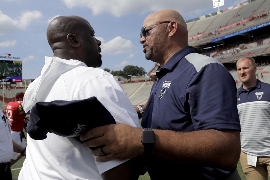 Maryland head coach Michael Locksley, left, shakes hands with Howard head coach Ron Prince after an NCAA college football game, Saturday, Aug. 31, 2019, in College Park, Md. Maryland won 79-0. (AP Photo/Julio Cortez)