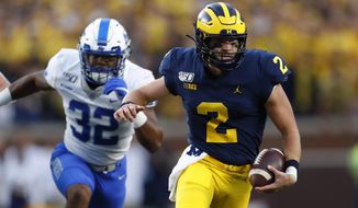 Michigan quarterback Shea Patterson (2) runs past Middle Tennessee linebacker Chris Melton (32) in the first half of an NCAA college football game in Ann Arbor, Mich., Saturday, Aug. 31, 2019. (AP Photo/Paul Sancya)
