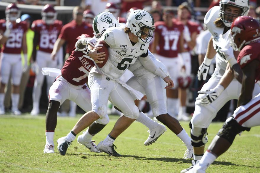 Portland State quarterback Davis Alexander tries to get away from Arkansas defender Joe Foucha as he scrambles out of the pocket in the first half of an NCAA college football game, Saturday, Aug. 31, 2019 in Fayetteville, Ark. (AP Photo/Michael Woods)
