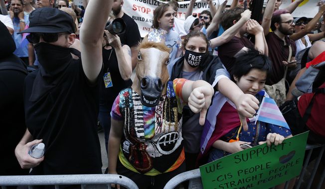 Counterprotesters, including one wearing a horse mask, line the route of the Straight Pride Parade in Boston, Saturday, Aug. 31, 2019. (AP Photo/Michael Dwyer)
