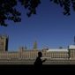A pedestrian passes Britain&#x27;s Houses of Parliament on the bank of The River Thames in London, Thursday, Aug. 29, 2019. Jacob Rees-Mogg, The leader of the British House of Commons has defended Prime Minister Boris Johnson&#x27;s move to suspend parlliament, a move that gives his political opponents less time to block a no-deal Brexit before the October 31 withdrawal deadline. (AP Photo/Kirsty Wigglesworth)
