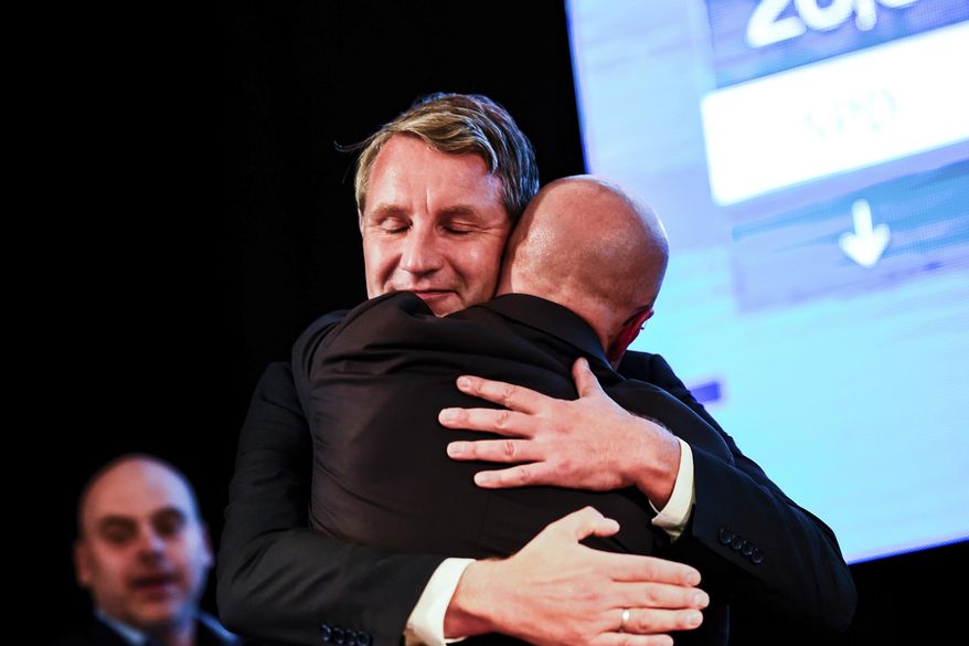 Top candidate of right-wing party Alternative for Germany, AfD, for the elections at the federal state Brandenburg Andreas Kalbitz, right, is embraced by AfD Thuringia chairman Bjoern Hoecke at an election party in Werder, near Potsdam, Sunday, Sept. 1, 2019. The citizens of the German federal states Saxony and Brandenburg elected their new parliament. ( Gregor Fischer/dpa via AP)