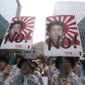South Korean protesters with images of Japanese Prime Minister Shinzo Abe shout slogans during a rally to mark the South Korean Liberation Day from Japanese colonial rule in 1945, in front of the Japanese Embassy in Seoul, South Korea, Thursday, Aug. 15, 2019. South Korean President Moon Jae-in on Thursday offered an olive branch to Japan to end a tense trade dispute, saying Seoul will &quot;gladly join hands&quot; if Tokyo to accepts calls to resolve it through dialogue. (AP Photo/Ahn Young-joon)