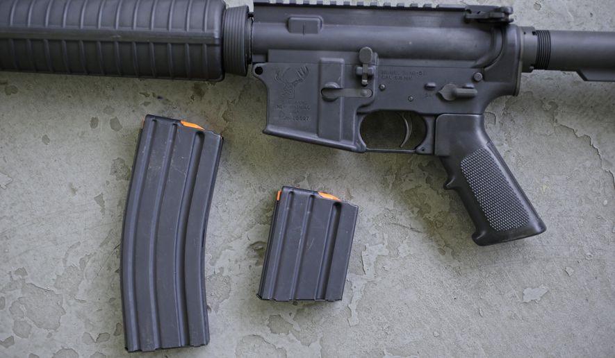 In this April 10, 2013, file photo, a stag arms AR-15 rifle with 30 round, left, and 10 round magazines is displayed in New Britain, Conn.  (AP Photo/Charles Krupa, File) **FILE**