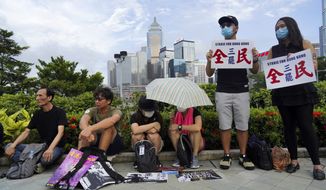 Protesters hold placard read &quot;Strike for Hong Kong&quot; as others listens to speech during continuing pro-democracy rallies in Tamar Park, Hong Kong, on Tuesday, Sept. 3, 2019. Hong Kong leader Carrie Lam said Tuesday she has never tendered her resignation to China over the anti-government protests that have roiled the city for three months. (AP Photo/Vincent Yu)