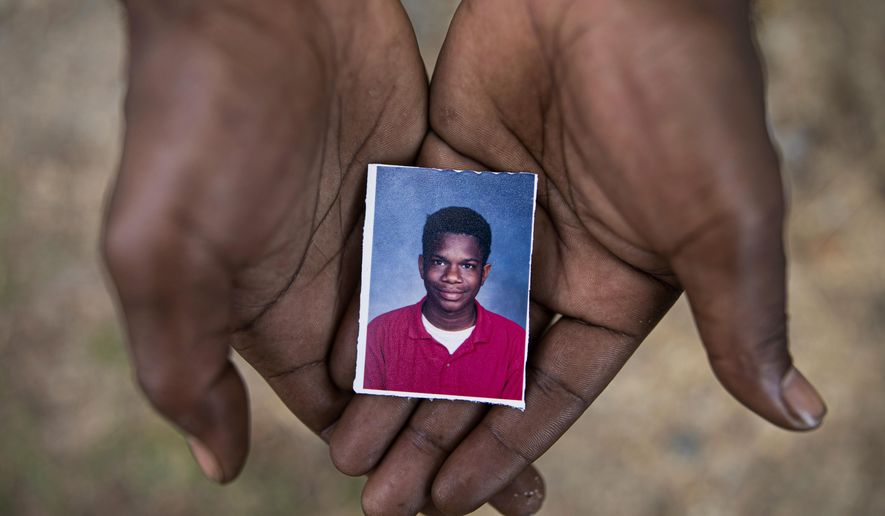 Joshua K. Love, 36, holds a photograph of himself taken at about the time he says he was sexually abused at St. Francis of Assisi School by two Franciscan friars, Brother Paul West and the late Brother Donald Lucas, in Greenwood, Miss., Monday, June 10, 2019. (AP Photo/Wong Maye-E)