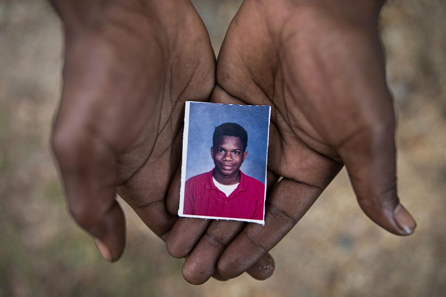 Joshua K. Love, 36, holds a photograph of himself taken at about the time he says he was sexually abused at St. Francis of Assisi School by two Franciscan friars, Brother Paul West and the late Brother Donald Lucas, in Greenwood, Miss., Monday, June 10, 2019. (AP Photo/Wong Maye-E)
