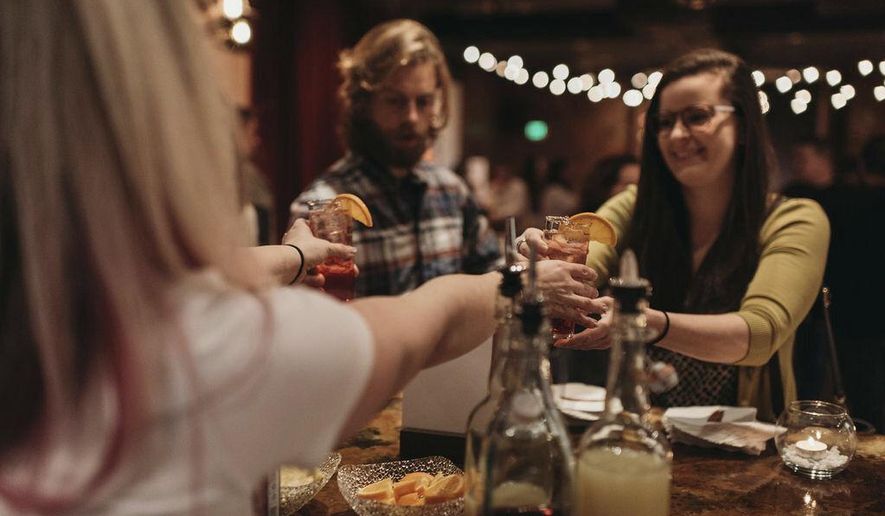In this Jan. 17, 2019 photo, a bartender serves patrons Rae of Sunshine mocktails at Sans Bar pop up bar at The Factory Luxe in Seattle, a Marnie Rae launch party for National Mocktail Week. (Saleina Marie Photography via AP)