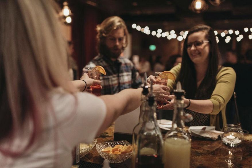 In this Jan. 17, 2019 photo, a bartender serves patrons Rae of Sunshine mocktails at Sans Bar pop up bar at The Factory Luxe in Seattle, a Marnie Rae launch party for National Mocktail Week. (Saleina Marie Photography via AP)