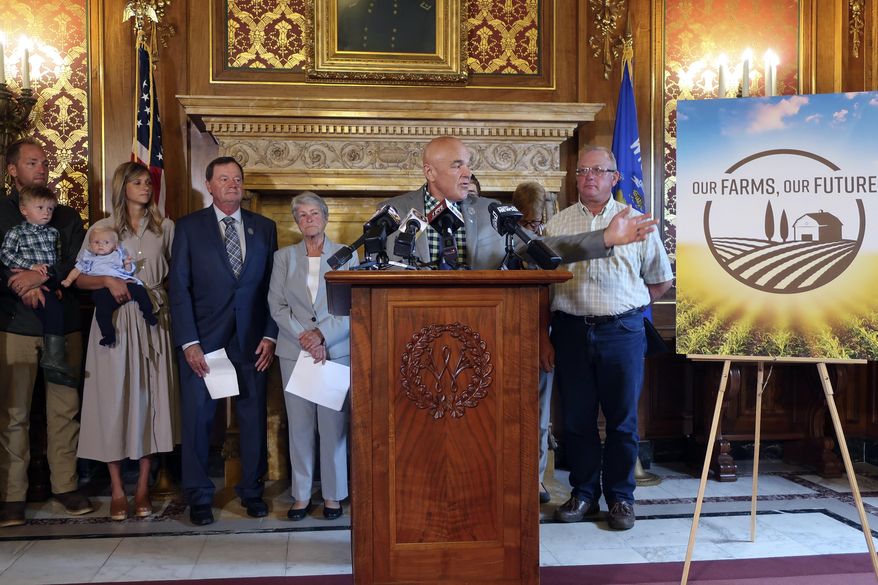 Democratic state Rep. David Considine gathers with supporters of three measures designed to help struggling Wisconsin farmers, Tuesday, Sept. 3, 2019, in Madison, Wis. Lawmakers, farmers and other supporters spoke in favor of the bill at a Capitol news conference Tuesday. (AP Photo/Scott Bauer)