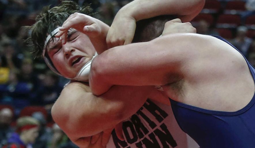 FILE - In this Feb. 18, 2017, file photo, North Linn's Kyler Schott, left, wrestles Iowa City Regina's Jared Brinkman in their 285-pound title match during the state Class 1A finals in Des Moines, Iowa. Schott is slated to make his first career NCAA college football start for Iowa against Rutgers on Saturday. Schott earned all-state honors in football and on the mat for North Linn High. (Bryon Houlgrave/The Des Moines Register via AP, File )