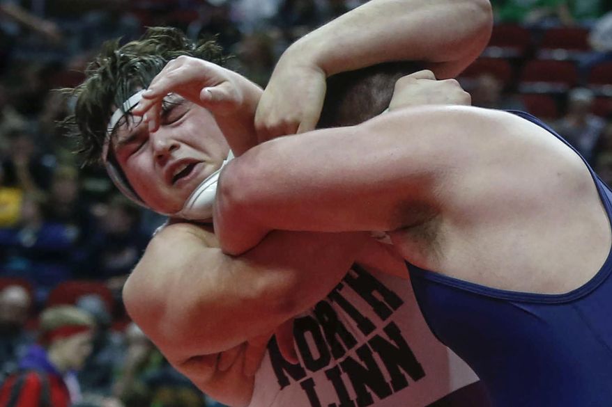 FILE - In this Feb. 18, 2017, file photo, North Linn's Kyler Schott, left, wrestles Iowa City Regina's Jared Brinkman in their 285-pound title match during the state Class 1A finals in Des Moines, Iowa. Schott is slated to make his first career NCAA college football start for Iowa against Rutgers on Saturday. Schott earned all-state honors in football and on the mat for North Linn High. (Bryon Houlgrave/The Des Moines Register via AP, File )