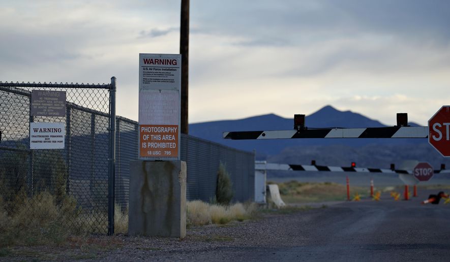 FILE - In this July 22, 2019, file photo, signs warn about trespassing at an entrance to the Nevada Test and Training Range near Area 51 outside of Rachel, Nev. A rural Nevada county has given final go-aheads to two events centered around a "Storm Area 51" drive that began as an internet joke. Lincoln County commissioners Tuesday, Sept. 3, 2019, accepted a promoter's plan to hold a music festival for 5,000 people in tiny Hiko, and an inn owner's effort to let perhaps 10,000 camp on her property in Rachel, the town closest to the once top-secret Area 51 military base. (AP Photo/John Locher, File)