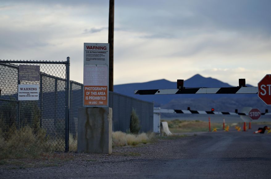FILE - In this July 22, 2019, file photo, signs warn about trespassing at an entrance to the Nevada Test and Training Range near Area 51 outside of Rachel, Nev. A rural Nevada county has given final go-aheads to two events centered around a "Storm Area 51" drive that began as an internet joke. Lincoln County commissioners Tuesday, Sept. 3, 2019, accepted a promoter's plan to hold a music festival for 5,000 people in tiny Hiko, and an inn owner's effort to let perhaps 10,000 camp on her property in Rachel, the town closest to the once top-secret Area 51 military base. (AP Photo/John Locher, File)