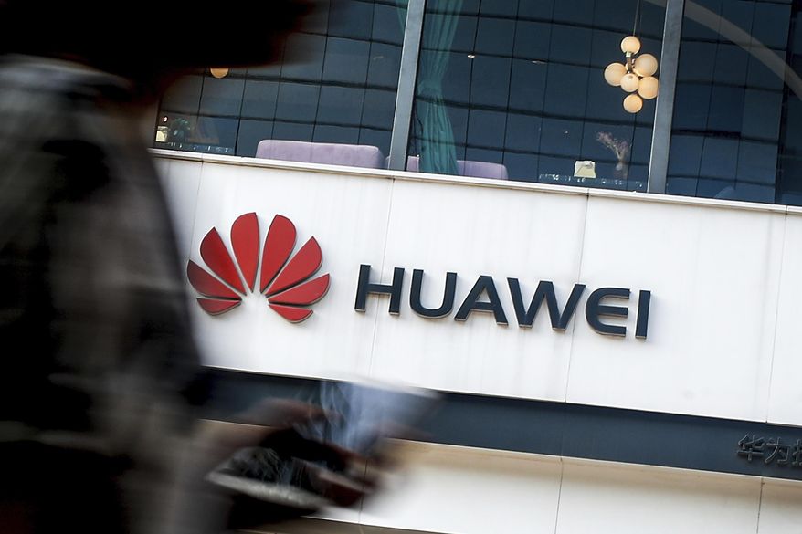 In this July 30, 2019, file photo a woman walks by a Huawei retail store in Beijing. Chinese tech giant Huawei has accused U.S. authorities of trying to coerce employees to gather information on the company and of trying to break into its information systems. The company, the target of U.S. accusations that it is a security threat, said Wednesday, Sept. 4, that American officials were using &amp;quot;unscrupulous means&amp;quot; to disrupt its business. (AP Photo/Andy Wong, File)
