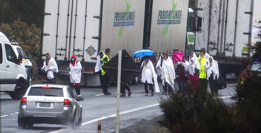 Survivors from a tourist bus crash walk along the highway in the Mamaku Ranges near Rotorua, New Zealand, Wednesday, Sept. 4. 2019. A bus carrying a group of Chinese tourists crashed near a popular New Zealand tourist town. (Ben Fraser/Rotorua Daily Post via AP)