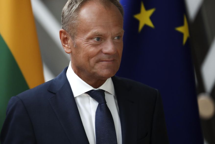European Council President Donald Tusk walks by the EU flag prior to a meeting with Lithuania&#39;s Gitanas Nauseda at the European Council headquarters in Brussels, Thursday, Sept. 5, 2019. The British parliament moved to take a no-deal Brexit off the table, raising questions about whether the deadline for Britain to leave should be pushed back beyond October 31. (AP Photo/Francisco Seco)