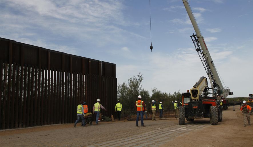 In this Aug. 23, 2019 file photo, workers break ground on new border wall construction about 20 miles west of Santa Teresa, N.M. Construction on a Pentagon-funded portion of the border wall began near Yuma, Arizona, this week, just as federal authorities announced they are diverting even more defense funds for wall projects. Crews began constructing a 30-foot steel fence along the Colorado River this week. (AP Photo/Cedar Attanasio, File)