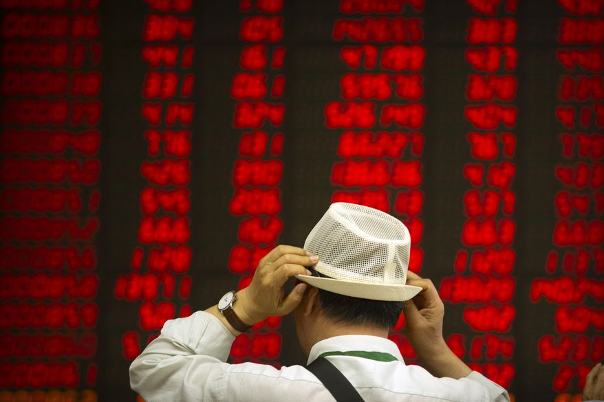 A Chinese investor adjusts his hat as he monitors stock prices at a brokerage house in Beijing, Thursday, Sept. 5, 2019. Asian shares were mostly higher Thursday amid encouraging global developments, including British lawmakers seeking a less chaotic exit from the European Union and easing political tensions in Hong Kong. (AP Photo/Mark Schiefelbein)