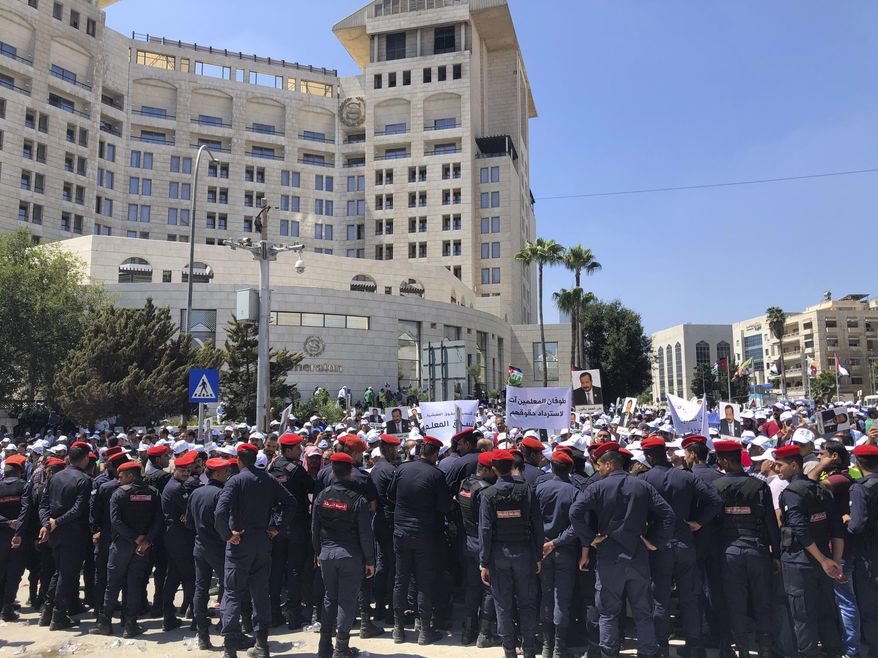 Security forces block a road as teachers protest in Amman, Jordan, Thursday, Sept. 5, 2019. Thousands of Jordanian teachers held a protest demanding higher wages, with some scuffling with security forces. Organizers of Thursday’s demonstration in the capital, Amman, say the government has yet to deliver on a 50% wage increase agreed upon in 2014. (AP Photo/Omar Akour)