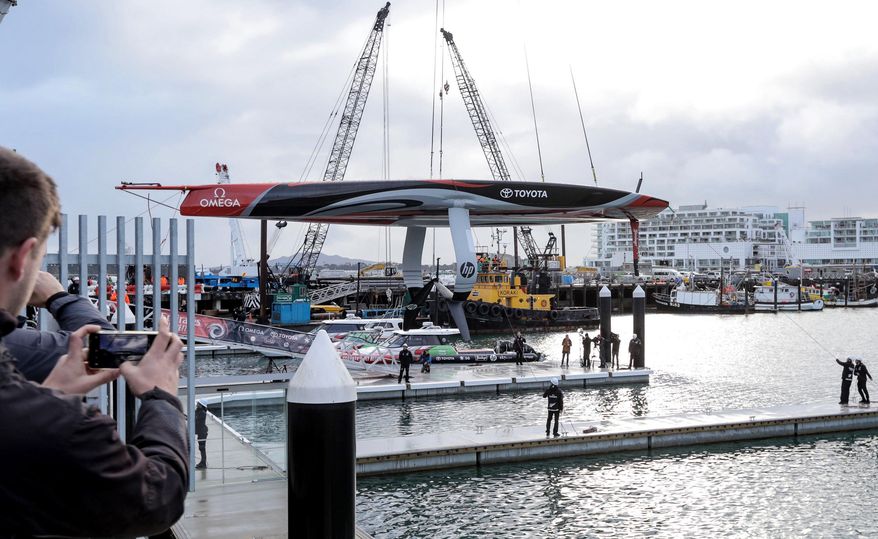 America's Cup defending champions Team New Zealand lowers its revolutionary foiling mono-hull sailboat into the water at its official launch at the Viaduct Basin in Auckland, New Zealand, Friday Sept. 6, 2019. Auckland will host the 36th America's Cup in 2021. (Michael Craig/NZ Herald via AP)