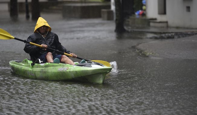 Johnny Crawford navigates his kayak down a flooded street, Thursday, Sept. 5, 2019, in Charleston, S.C., following Hurricane Dorian. The downtown neighborhood is prone to floodwaters, even without a tropical weather event. (AP Photo/Meg Kinnard)