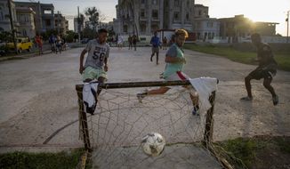 Youths plays soccer in the Vedado neighborhood of Havana, Cuba, Aug. 18, 2019. Six decades ago, the U.S. implemented an embargo against Cuba with the objective of stifling the economy and bringing down the communist government, however, according to many experts it instead harmed the population while generating resilience. (AP Photo/Ismael Francisco)