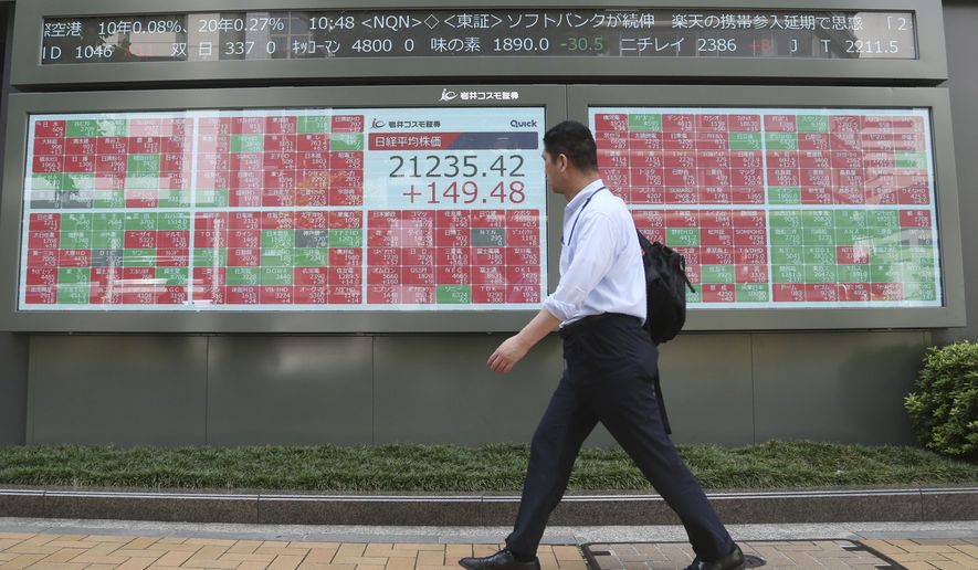 A man walks by an electronic stock board of a securities firm in Tokyo, Friday, Sept. 6, 2019. Asian shares rose Friday as investors cheered plans for more trade negotiations between Washington and Beijing and drew encouragement from positive data about the U.S. economy. (AP Photo/Koji Sasahara)