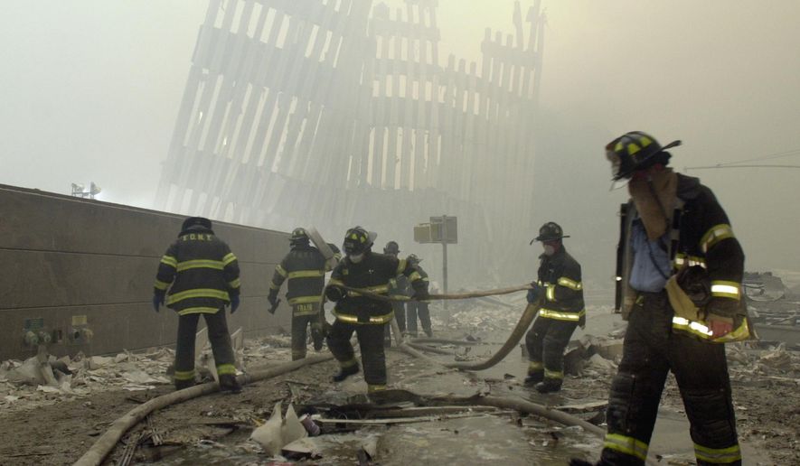 FILE - In this Sept. 11, 2001 file photo, firefighters work beneath the destroyed mullions, the vertical struts which once faced the outer walls of the World Trade Center towers, after a terrorist attack on the twin towers in New York. New research released on Friday, Sept. 6, 2019 suggests firefighters who arrived early or spent more time at the World Trade Center site after the 9/11 attacks seem to have a greater risk of developing heart problems than those who came later and stayed less. (AP Photo/Mark Lennihan)