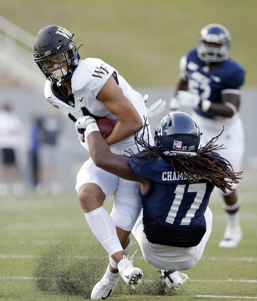 Wake Forest wide receiver Sage Surratt, left, breaks a tackle-attempt by Rice linebacker Treshawn Chamberlain (17) during the first half of an NCAA college football game Friday, Sept. 6, 2019, in Houston. (AP Photo/Michael Wyke)