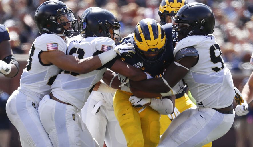 Army defenders stop Michigan running back Zach Charbonnet (24) in the second half of an NCAA college football game in Ann Arbor, Mich., Saturday, Sept. 7, 2019. Michigan won 24-21 in overtime. (AP Photo/Paul Sancya)