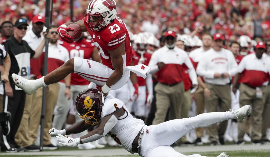 Wisconsin's Jonathan Taylor tries to leap over Central Michigan's Da'Quaun Jamison during the first half of an NCAA college football game Saturday, Sept. 7, 2019, in Madison, Wis. (AP Photo/Morry Gash)