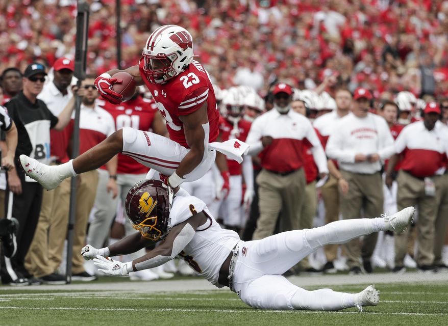 Wisconsin's Jonathan Taylor tries to leap over Central Michigan's Da'Quaun Jamison during the first half of an NCAA college football game Saturday, Sept. 7, 2019, in Madison, Wis. (AP Photo/Morry Gash)