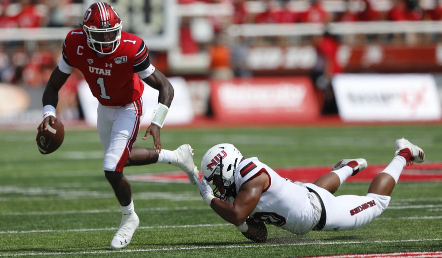 Utah quarterback Tyler Huntley (1) breaks from a Northern Illinois tackler in the first half of an NCAA college football game Saturday, Sept. 9, 2019, Salt Lake City. (AP Photo/Rick Bowmer)