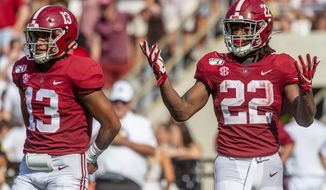Alabama quarterback Tua Tagovailoa (13) and running back Najee Harris (22) look back to the sideline for a play during the first half of an NCAA college football game against New Mexico State, Saturday, Sept. 7, 2019, in Tuscaloosa, Ala. (AP Photo/Vasha Hunt)