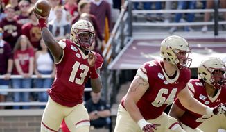 Boston College quarterback Anthony Brown (13) looks to pass as Ben Petrula (64) and AJ Dillon (2) block during the first half of an NCAA college football game, Saturday, Sept. 7, 2019, in Boston. (AP Photo/Mary Schwalm)